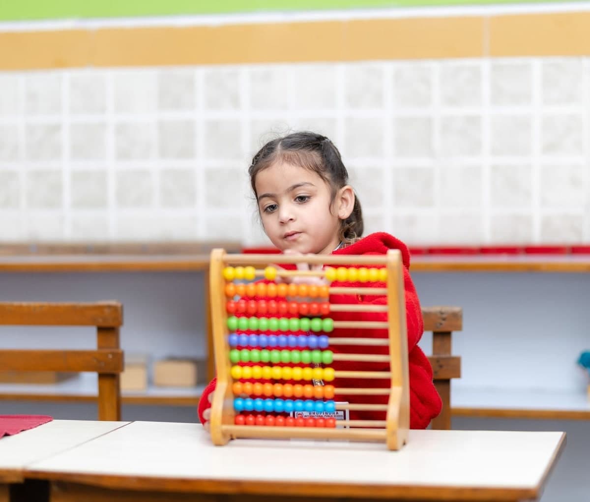 Young child learning mental maths on a colourful abacus